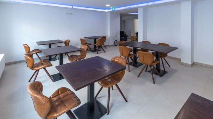 Ein modernes Café mit braunen Ledersesseln und dunklen Holztischen in einem hellen Raum., © Kronenstuben Boutique-Hotel Ein modernes Café mit braunen Ledersesseln und dunklen Holztischen in einem hellen Raum., © Kronenstuben Boutique-Hotel