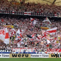 VfB Stuttgart Fans in der Mercedes-Benz Arena schwenken Fahnen und halten Banner hoch. Die Trib&uuml;ne ist voll besetzt und in den Vereinsfarben dekoriert., &copy; SMG