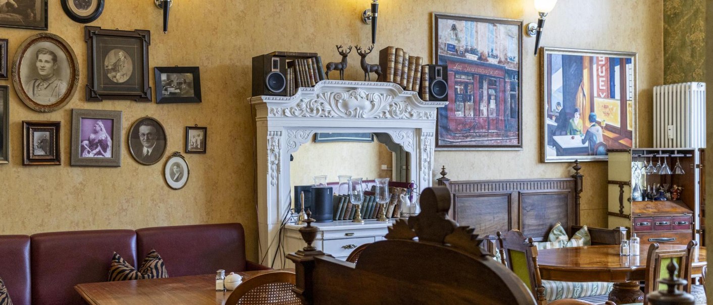 Ein gemütliches Café mit antiken Möbeln, gerahmten Bildern und dekorativen Elementen an den Wänden., © SMG, Sarah Schmid Ein gemütliches Café mit antiken Möbeln, gerahmten Bildern und dekorativen Elementen an den Wänden., © SMG, Sarah Schmid