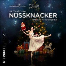Eine Ballerina in weißem Kleid tanzt vor einem geschmückten Weihnachtsbaum, umgeben von Geschenken. Der Titel "Nussknacker - Ballett mit Orchester" ist zu sehen., © links im Bild Eine Ballerina in weißem Kleid tanzt vor einem geschmückten Weihnachtsbaum, umgeben von Geschenken. Der Titel "Nussknacker - Ballett mit Orchester" ist zu sehen., © links im Bild