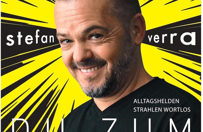 Ein l&auml;chelnder Mann vor einem gelben Hintergrund mit dem Titel 'Du zum Superdu' von Stefan Verra., &copy; Theaterhaus Stuttgart e.V.