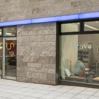 Large window fronts that offer a view of the caf&eacute; inside: Wooden tables, white cushions., &copy; Stuttgart-Marketing GmbH, Sarah Schmid