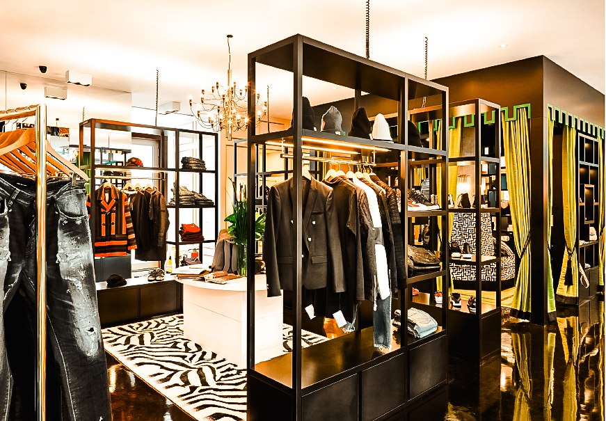 Modernes Bekleidungsgeschäft mit stilvollen Regalen, Kleidung und Accessoires. Ein Kronleuchter hängt von der Decke, der Boden ist glänzend., © Abseits Stuttgart