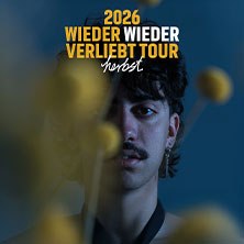 Ein Mann mit Schnurrbart schaut durch gelbe Blumen. Text: '2026 Wieder Wieder Verliebt Tour herbst'., © links im Bild Ein Mann mit Schnurrbart schaut durch gelbe Blumen. Text: '2026 Wieder Wieder Verliebt Tour herbst'., © links im Bild