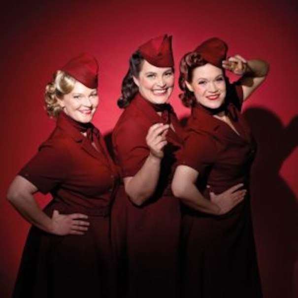 Drei Frauen in roten Retro-Kleidern und Hüten posieren lächelnd vor rotem Hintergrund., © Altes Schauspielhaus und Komödie im Marquardt e.V. Drei Frauen in roten Retro-Kleidern und Hüten posieren lächelnd vor rotem Hintergrund., © Altes Schauspielhaus und Komödie im Marquardt e.V.