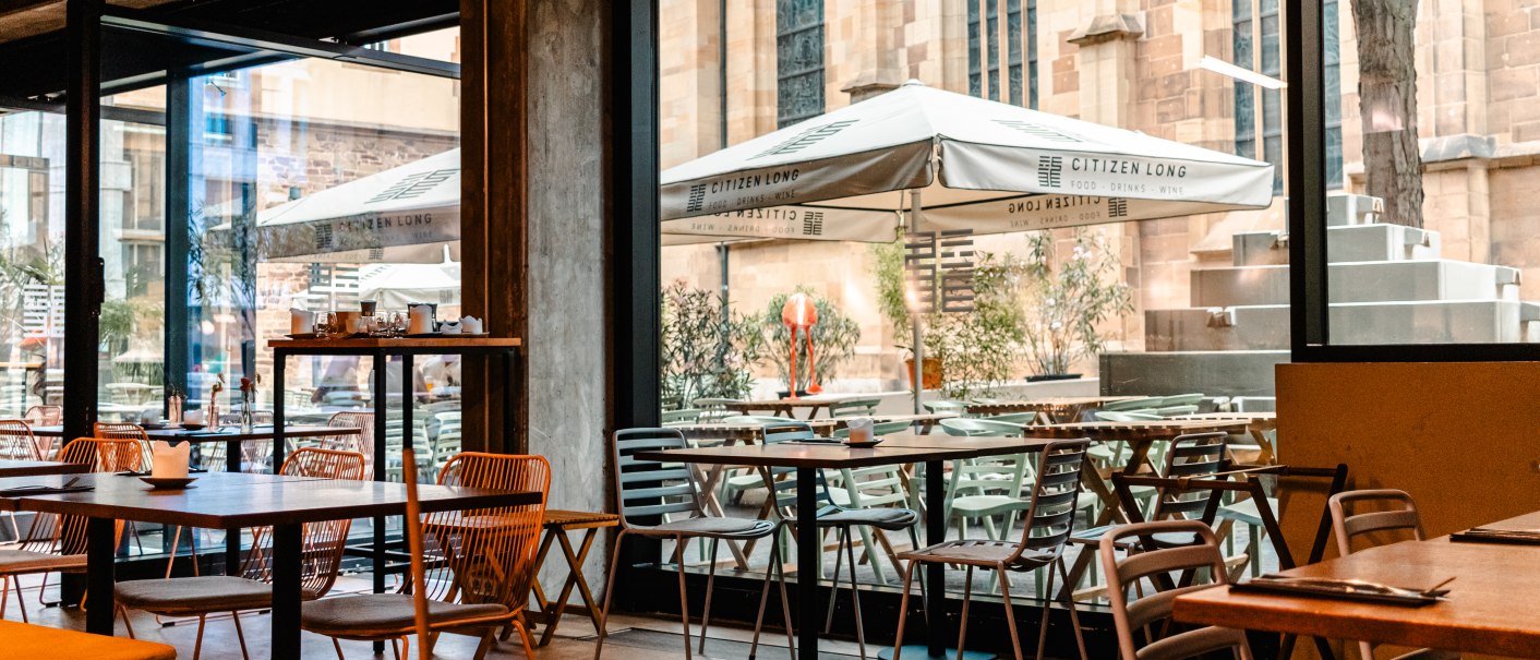 Modernes Café mit Holzmöbeln, großen Fenstern und Blick auf eine Terrasse mit "Citizen Long"-Sonnenschirmen., © SMG Stuttgart Marketing GmbH - Sarah Schmid Modernes Café mit Holzmöbeln, großen Fenstern und Blick auf eine Terrasse mit "Citizen Long"-Sonnenschirmen., © SMG Stuttgart Marketing GmbH - Sarah Schmid