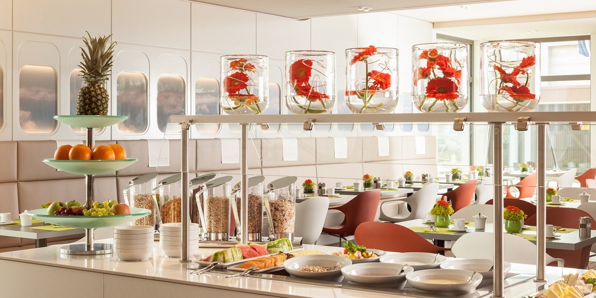 Modern restaurant with stylish buffet. Fruit, muesli and flower arrangements in jars. Bright, inviting atmosphere with elegant seating., &copy; Essential by Dorint