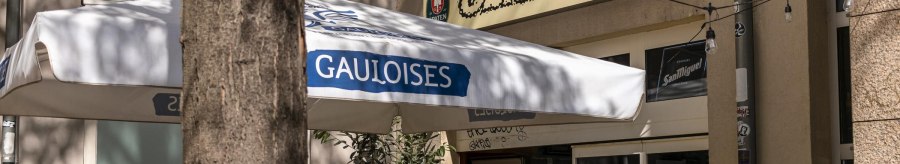 Entrance of a caf&eacute; called Oblamow with Gauloises parasol and plants. Exterior lighting and Franciscan and San Miguel signs visible., &copy; SMG, Sarah Schmid