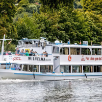 The excursion boat sails on a river surrounded by lush greenery. There are many passengers on board enjoying the view., © NeckarFlair MS Wilhelma Betriebsgesellschaft mbH The excursion boat sails on a river surrounded by lush greenery. There are many passengers on board enjoying the view., © NeckarFlair MS Wilhelma Betriebsgesellschaft mbH