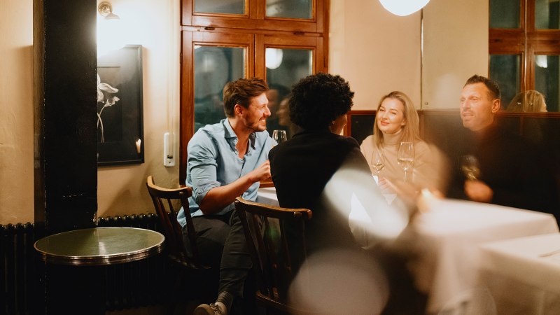 Vier Personen sitzen in einer gemütlichen Weinstube, unterhalten sich und genießen Wein. Die Atmosphäre ist warm und einladend., © Stuttgart-Marketing GmbH, Alwin Maigler Vier Personen sitzen in einer gemütlichen Weinstube, unterhalten sich und genießen Wein. Die Atmosphäre ist warm und einladend., © Stuttgart-Marketing GmbH, Alwin Maigler