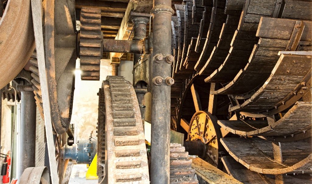 Close-up of an old water wheel with large cogwheels and wooden elements in an industrial setting., &copy; ECOINN Hotel am Campus