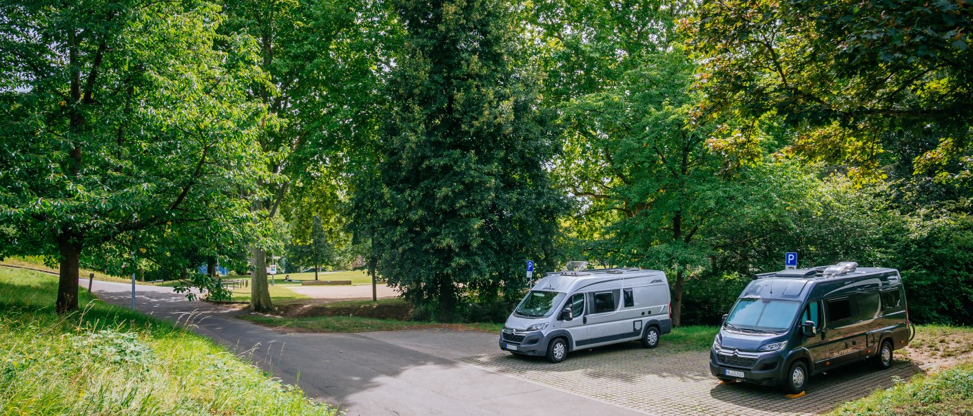 Zwei Wohnmobile parken auf einem Stellplatz im Grünen, umgeben von hohen Bäumen und einer Wiese., © Stuttgart-Marketing GmbH, Thomas Niedermüller Zwei Wohnmobile parken auf einem Stellplatz im Grünen, umgeben von hohen Bäumen und einer Wiese., © Stuttgart-Marketing GmbH, Thomas Niedermüller