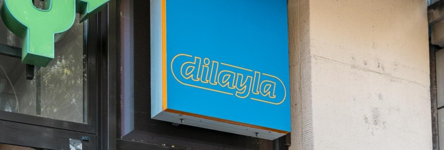 Blue sign with yellow lettering 'dilayla' on a building wall, next to it a green arrow., © Stuttgart Marketing GmbH, Sarah Schmid Blue sign with yellow lettering 'dilayla' on a building wall, next to it a green arrow., © Stuttgart Marketing GmbH, Sarah Schmid