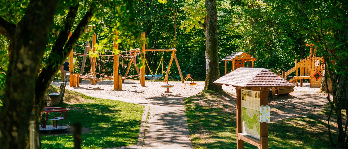 A playground surrounded by greenery with swings, climbing equipment and an information board. The area is surrounded by trees and is inviting and sunny., &copy; Stuttgart-Marketing GmbH, Thomas Niederm&uuml;ller