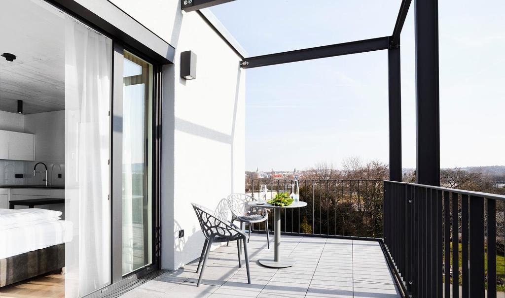 Moderne Terrasse mit Tisch und Stühlen, angrenzend an ein helles Apartment mit offener Küche und großem Fenster., © livisit bergapartments Moderne Terrasse mit Tisch und Stühlen, angrenzend an ein helles Apartment mit offener Küche und großem Fenster., © livisit bergapartments