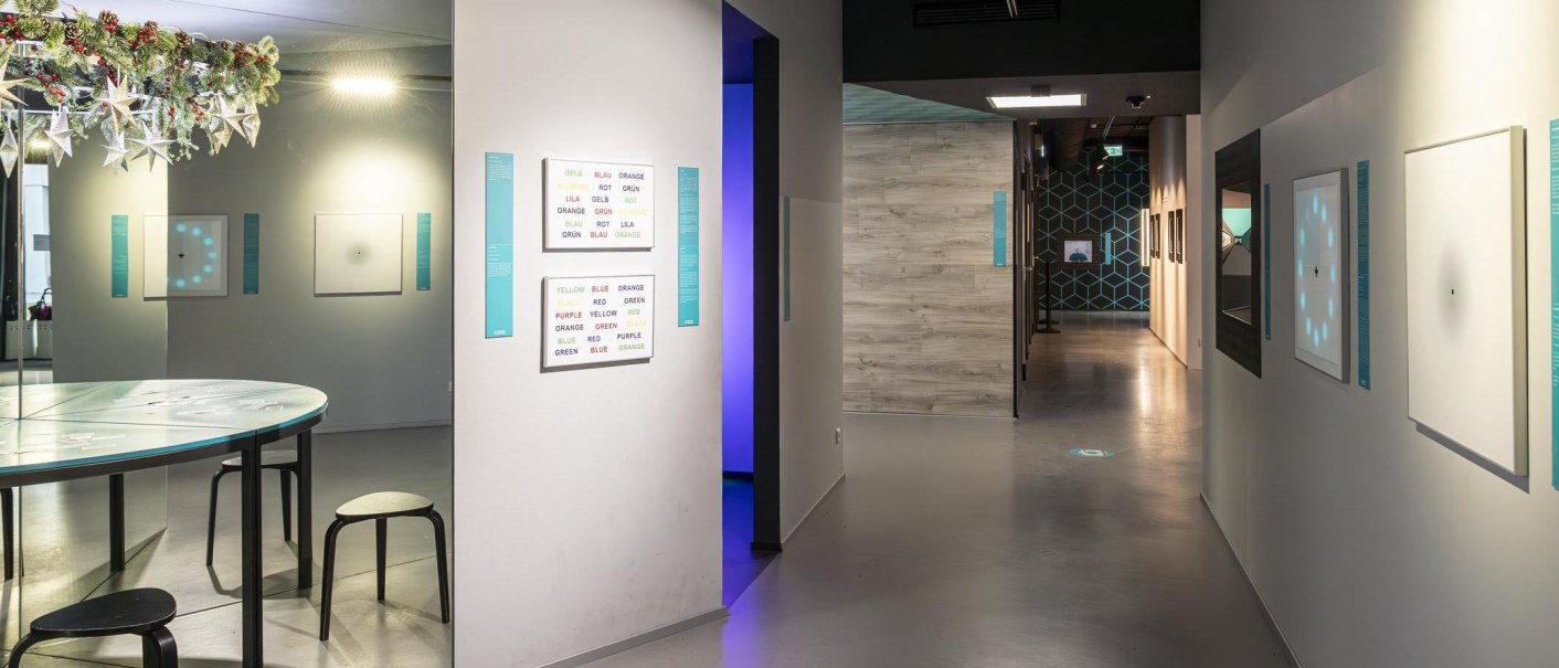 Innenansicht des Museums der Illusionen Stuttgart mit optischen Täuschungen an den Wänden und einem Tisch mit Hockern., © Stuttgart-Marketing GmbH, Sarah Schmid Innenansicht des Museums der Illusionen Stuttgart mit optischen Täuschungen an den Wänden und einem Tisch mit Hockern., © Stuttgart-Marketing GmbH, Sarah Schmid