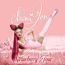 Eine Person in einem rosa Outfit mit Erdbeer-Accessoires posiert auf einem rosa Hintergrund. Der Schriftzug "Naomi Jon - Strawberry Tour" ist sichtbar., © links im Bild Eine Person in einem rosa Outfit mit Erdbeer-Accessoires posiert auf einem rosa Hintergrund. Der Schriftzug "Naomi Jon - Strawberry Tour" ist sichtbar., © links im Bild
