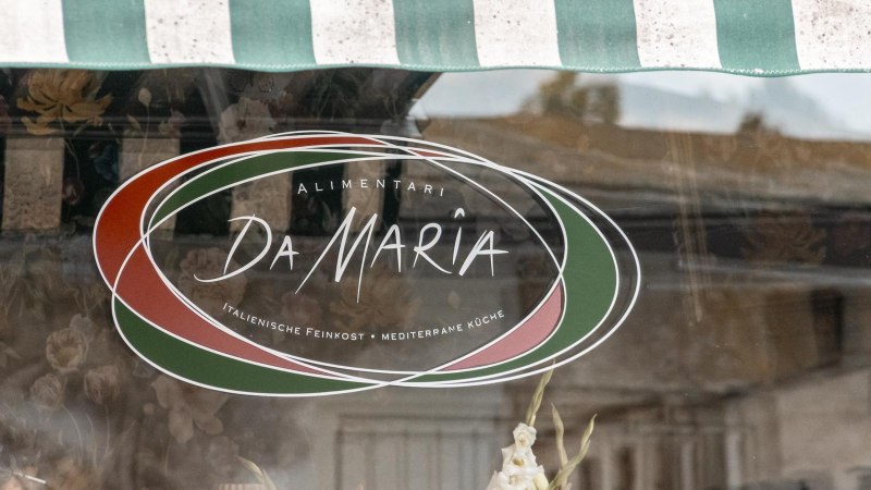 Schaufenster mit dem Logo von "Alimentari Da Maria". Es zeigt italienische Farben und bietet italienische Feinkost und mediterrane Küche an., © Stuttgart Marketing GmbH, Sarah Schmid Schaufenster mit dem Logo von "Alimentari Da Maria". Es zeigt italienische Farben und bietet italienische Feinkost und mediterrane Küche an., © Stuttgart Marketing GmbH, Sarah Schmid