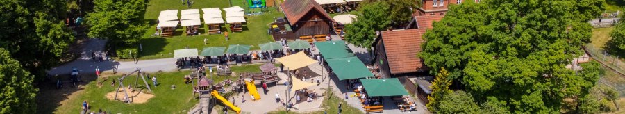 Aerial view of the Katzenbacher Hof, featuring a playground, beer garden, and green surroundings. People are enjoying the sunny weather outdoors., © Katzenbacher Hof Aerial view of the Katzenbacher Hof, featuring a playground, beer garden, and green surroundings. People are enjoying the sunny weather outdoors., © Katzenbacher Hof
