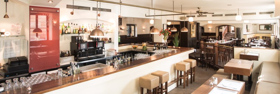 Stilvolles Restaurant mit Bar, Holzmöbeln und gedeckten Tischen. Helle Beleuchtung und gemütliche Atmosphäre., © Amadeus, Stuttgart