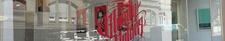Schaufenster der Bloody Colors Gallery mit rotem Schriftzug und Spiegelung der gegenüberliegenden Gebäude., © Horst Krick