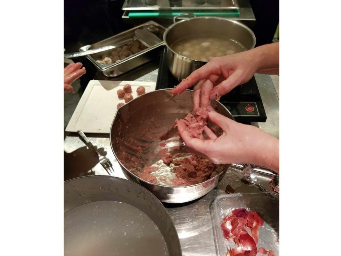 A person forms meatballs from minced meat in a bowl. Pots and trays with other ingredients can be seen in the background., © Kultweine-Kochwelten-Kunstücke - Kochschule Sonja Lenz A person forms meatballs from minced meat in a bowl. Pots and trays with other ingredients can be seen in the background., © Kultweine-Kochwelten-Kunstücke - Kochschule Sonja Lenz