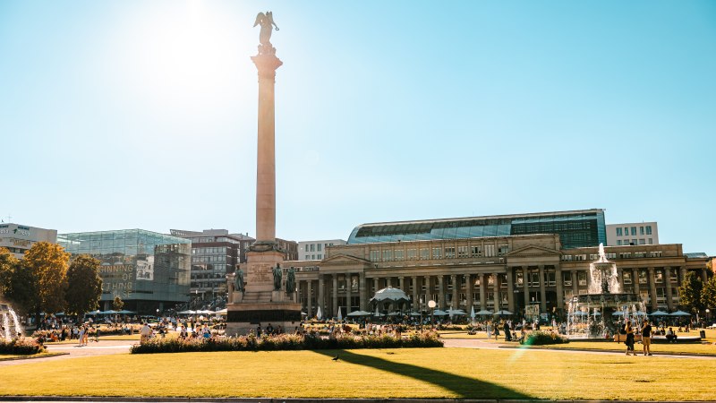 Der Schlossplatz in Stuttgart bei Sonnenschein, mit der Jubiläumssäule und dem Königsbau im Hintergrund. Menschen genießen den sonnigen Tag., © SMG Stuttgart Marketing GmbH - Sarah Schmid Der Schlossplatz in Stuttgart bei Sonnenschein, mit der Jubiläumssäule und dem Königsbau im Hintergrund. Menschen genießen den sonnigen Tag., © SMG Stuttgart Marketing GmbH - Sarah Schmid