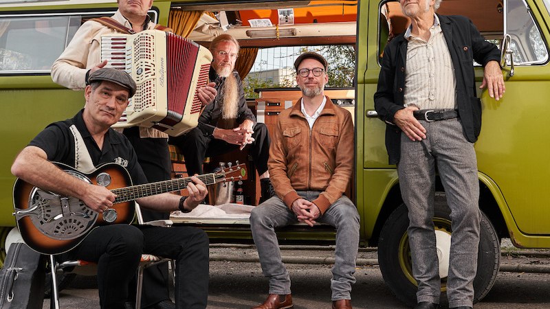 Fünf Männer stehen und sitzen vor einem grünen VW-Bus. Einer spielt Gitarre, ein anderer hält ein Akkordeon. Sie wirken entspannt und lässig., © Rosenau Kultur e.V. Fünf Männer stehen und sitzen vor einem grünen VW-Bus. Einer spielt Gitarre, ein anderer hält ein Akkordeon. Sie wirken entspannt und lässig., © Rosenau Kultur e.V.