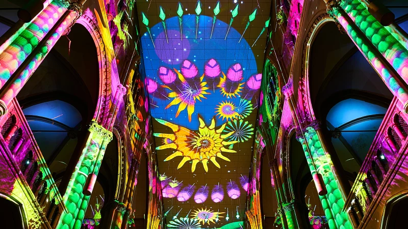 Farbenfrohe Lichtprojektionen im Kircheninneren der Stuttgarter Johanneskirche mit floralen Mustern auf Gewölben und Decke., © Andreas Kaiser Farbenfrohe Lichtprojektionen im Kircheninneren der Stuttgarter Johanneskirche mit floralen Mustern auf Gewölben und Decke., © Andreas Kaiser