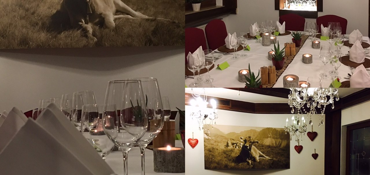 Elegant restaurant with a laid table, wine glasses and candles. A picture of cows in the mountains hangs on the wall., © TOMAS