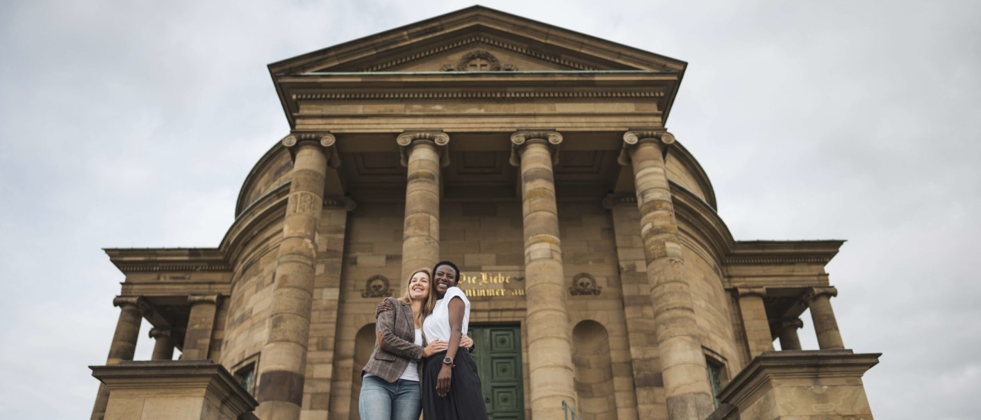 Two people embrace with a smile in front of the imposing fa&ccedil;ade of the Stuttgart burial chapel with its columns., &copy; Stuttgart-Marketing GmbH, wpsteinheisser