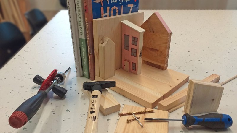 Ein Tisch mit Werkzeugen, Holzstücken und Büchern zum Thema Holzarbeiten. Ideal für ein DIY-Möbelupcycling-Projekt., © StadtPalais Stuttgart Ein Tisch mit Werkzeugen, Holzstücken und Büchern zum Thema Holzarbeiten. Ideal für ein DIY-Möbelupcycling-Projekt., © StadtPalais Stuttgart