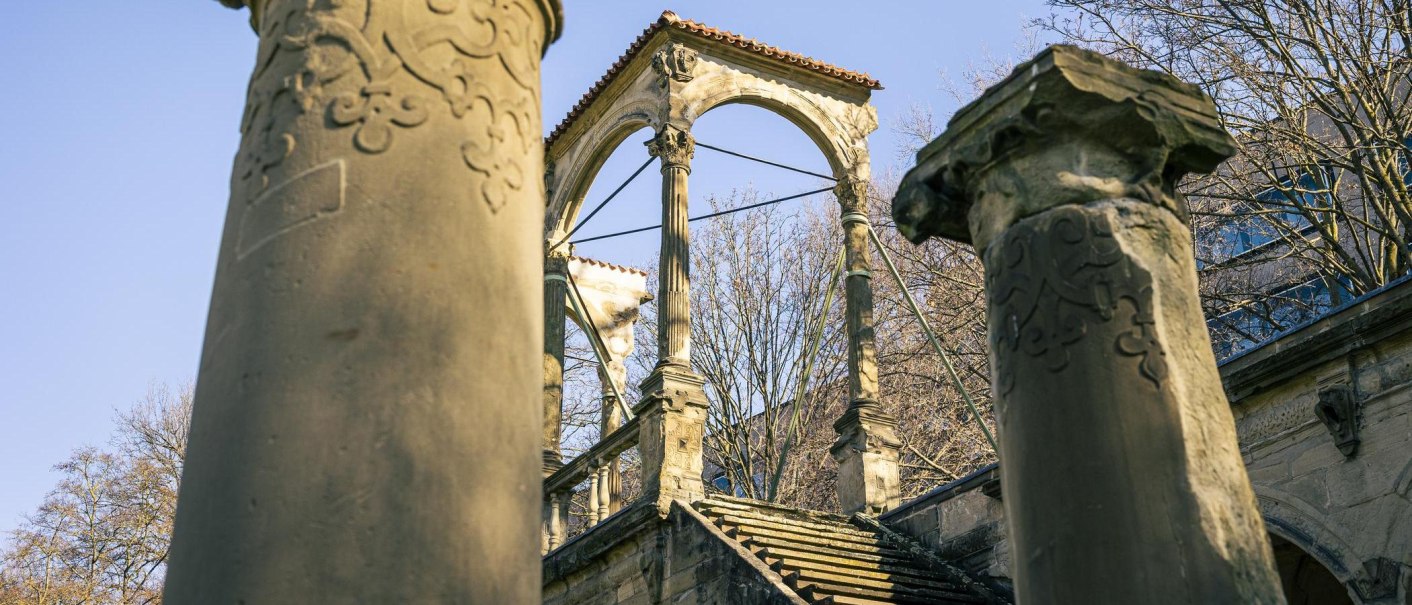 Ruin of the Neues Lusthaus with ornate columns and a staircase. Trees and a clear sky can be seen in the background., &copy; Stuttgart-Marketing GmbH, Sarah Schmid