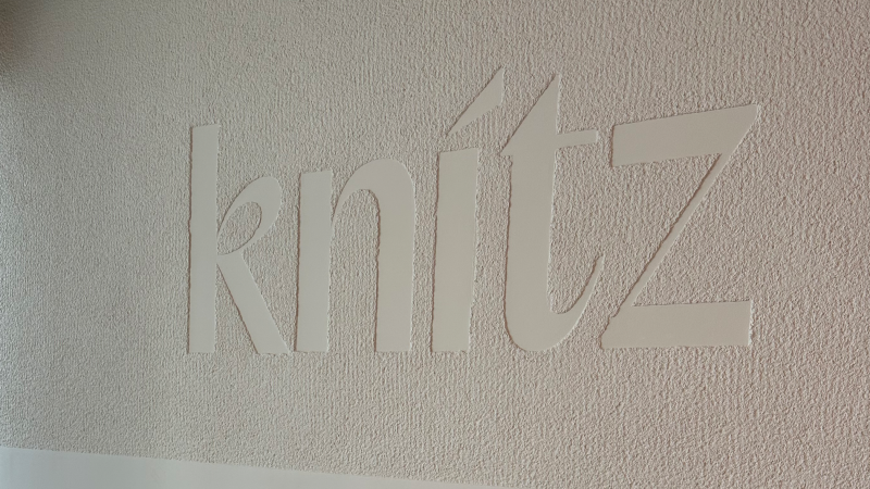 Das Logo des knitz Restaurants ist in großen, weißen Buchstaben auf einer strukturierten Wand zu sehen., © Stuttgart-Marketing GmbH Das Logo des knitz Restaurants ist in großen, weißen Buchstaben auf einer strukturierten Wand zu sehen., © Stuttgart-Marketing GmbH