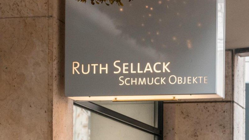 Ein Leuchtschild mit der Aufschrift 'Ruth Sellack Schmuck Objekte' hängt an einer Gebäudewand aus Stein., © SMG, Sarah Schmid Ein Leuchtschild mit der Aufschrift 'Ruth Sellack Schmuck Objekte' hängt an einer Gebäudewand aus Stein., © SMG, Sarah Schmid