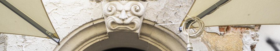 Steinfigur &uuml;ber einem Torbogen mit der Aufschrift 'transit BERGAMO'. Graffiti und verwitterte Wand im Hintergrund., &copy; SMG, Sarah Schmid
