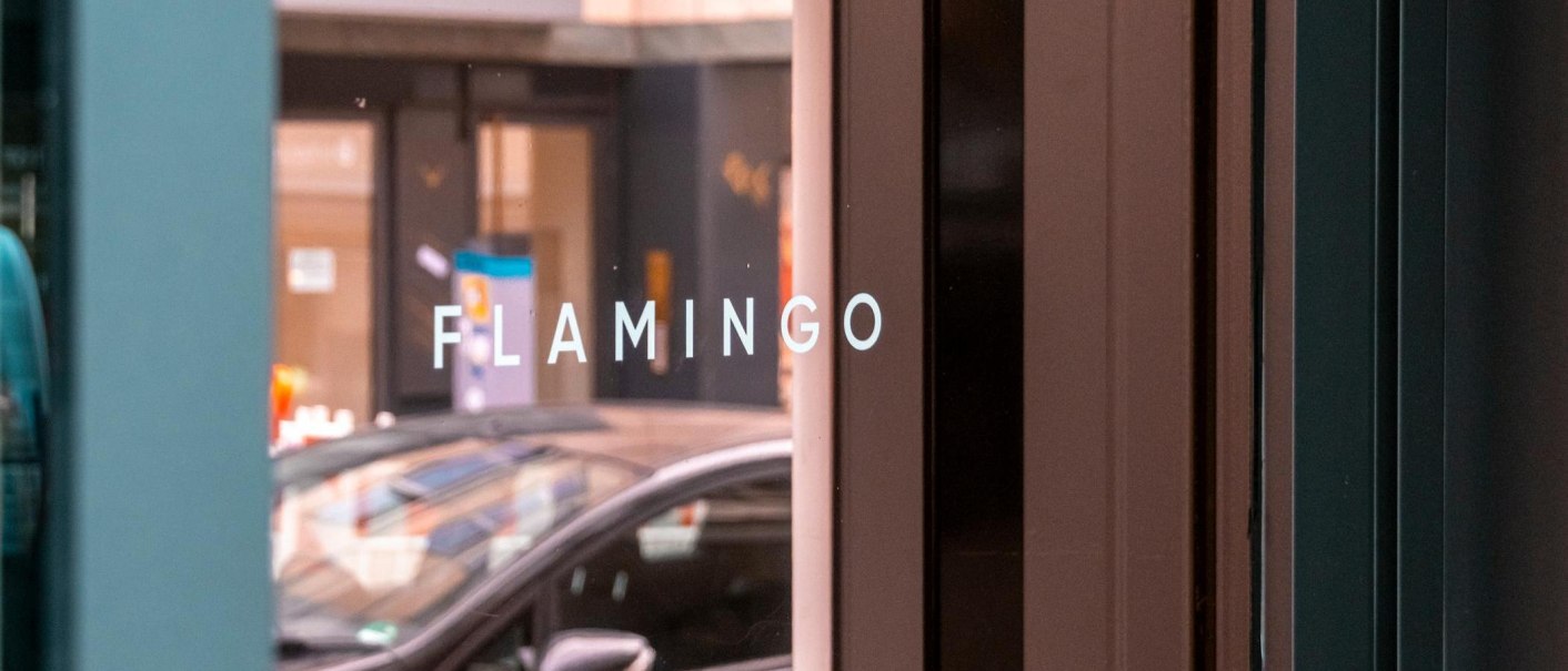 Wei&szlig;er Schriftzug "FLAMINGO" in Gro&szlig;buchstaben auf der verspiegelten Glasfront der Bar, &copy; SMG, Sarah Schmid