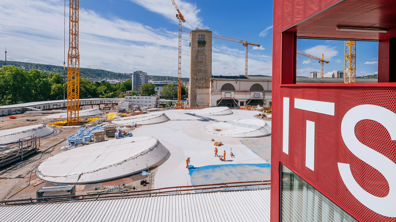 View of a construction site with several cranes and a red building with the inscription 'ITS' in the foreground., &copy; Thomas Niederm&uuml;ller