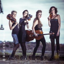 Vier Frauen in eleganter Kleidung posieren mit Streichinstrumenten in einer nat&uuml;rlichen Umgebung., &copy; links im Bild