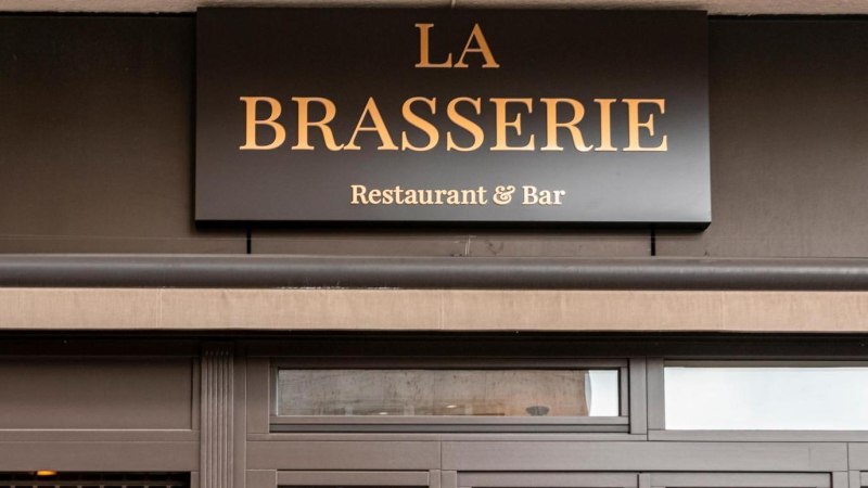 Das Bild zeigt das Eingangsschild eines Restaurants mit der Aufschrift 'La Brasserie Restaurant & Bar'., &copy; SMG, Sarah Schmid