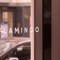 Wei&szlig;er Schriftzug "FLAMINGO" in Gro&szlig;buchstaben auf der verspiegelten Glasfront der Bar, &copy; SMG, Sarah Schmid