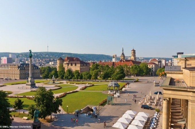 Panoramablick auf den Schlossplatz in Stuttgart, umgeben von historischen Gebäuden und Grünflächen unter klarem Himmel., © Stuttgart Marketing GmbH