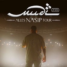 Person steht auf einer B&uuml;hne im Scheinwerferlicht, mit dem R&uuml;cken zur Kamera. Oben der Schriftzug 'Mudi - Alles Nasip Tour 2026'., &copy; links im Bild