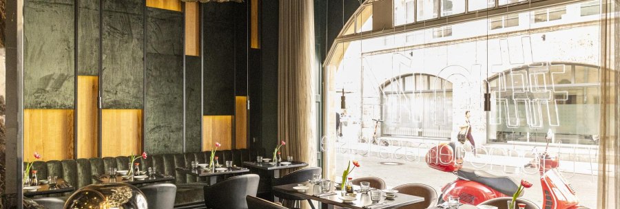 Elegantes Restaurant mit modernen Möbeln, großen Fenstern und stilvoller Dekoration. Draußen sind rote Motorroller zu sehen., © Stuttgart-Marketing GmbH, Sarah Schmid Elegantes Restaurant mit modernen Möbeln, großen Fenstern und stilvoller Dekoration. Draußen sind rote Motorroller zu sehen., © Stuttgart-Marketing GmbH, Sarah Schmid