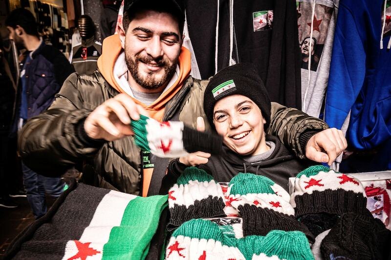 Die Sheikh Zayed Moschee in Abu Dhabi mit beeindruckender Architektur. Zwei Personen sind im Innenhof zu sehen, eine in traditioneller Kleidung, die andere beim Reinigen., © Theaterhaus Stuttgart e.V. Die Sheikh Zayed Moschee in Abu Dhabi mit beeindruckender Architektur. Zwei Personen sind im Innenhof zu sehen, eine in traditioneller Kleidung, die andere beim Reinigen., © Theaterhaus Stuttgart e.V.