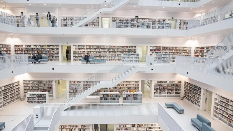 Interior view of Stuttgart City Library with several floors, white walls and shelves full of books. People move around the floors., © Stuttgart-Marketing GmbH, Sarah Schmid Interior view of Stuttgart City Library with several floors, white walls and shelves full of books. People move around the floors., © Stuttgart-Marketing GmbH, Sarah Schmid
