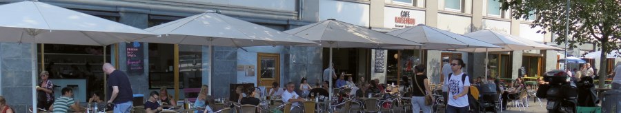 People sit under parasols in front of the Kaiserbau gelateria on Marienplatz. A few passers-by walk past., © Stuttgart-Marketing GmbH