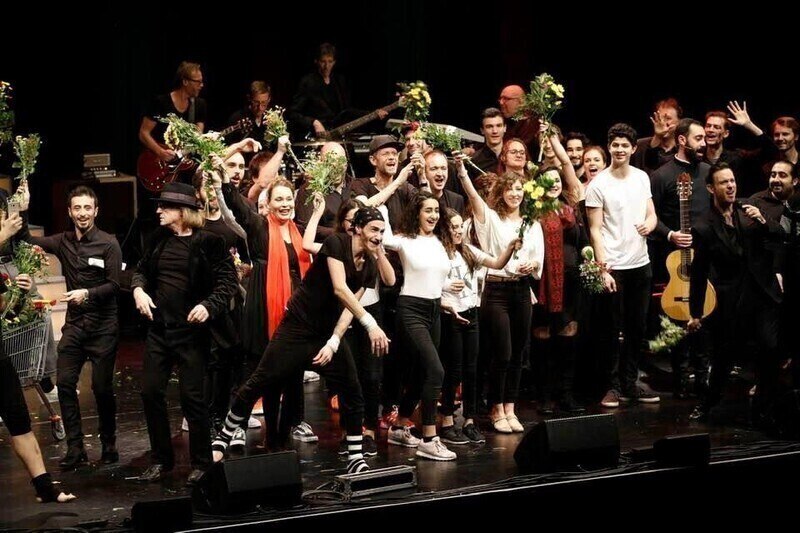 Artists celebrate on stage with bouquets of flowers in their hands. The atmosphere is exuberant and cheerful., © STUTTGARTER NACHRICHTEN Artists celebrate on stage with bouquets of flowers in their hands. The atmosphere is exuberant and cheerful., © STUTTGARTER NACHRICHTEN