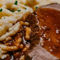 A plate of succulent roast in a dark sauce, served with spaetzle and garnished with chives., © SMG, Thomas Niedermüller A plate of succulent roast in a dark sauce, served with spaetzle and garnished with chives., © SMG, Thomas Niedermüller