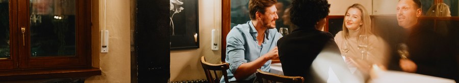 Vier Personen sitzen in einer gem&uuml;tlichen Weinstube, unterhalten sich und genie&szlig;en Wein. Die Atmosph&auml;re ist warm und einladend., &copy; Stuttgart-Marketing GmbH, Alwin Maigler